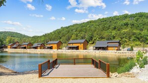 Um resort à beira do lago com cabanas de madeira e um píer de madeira.
