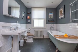 A bathroom with a white sink, toilet, and bathtub. - Charming 2BDR Terraced House with Garden Wimbledon (Greater London)