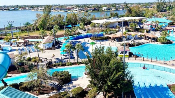 Et resort med flere swimmingpools, en strand og udsigt over vandet.