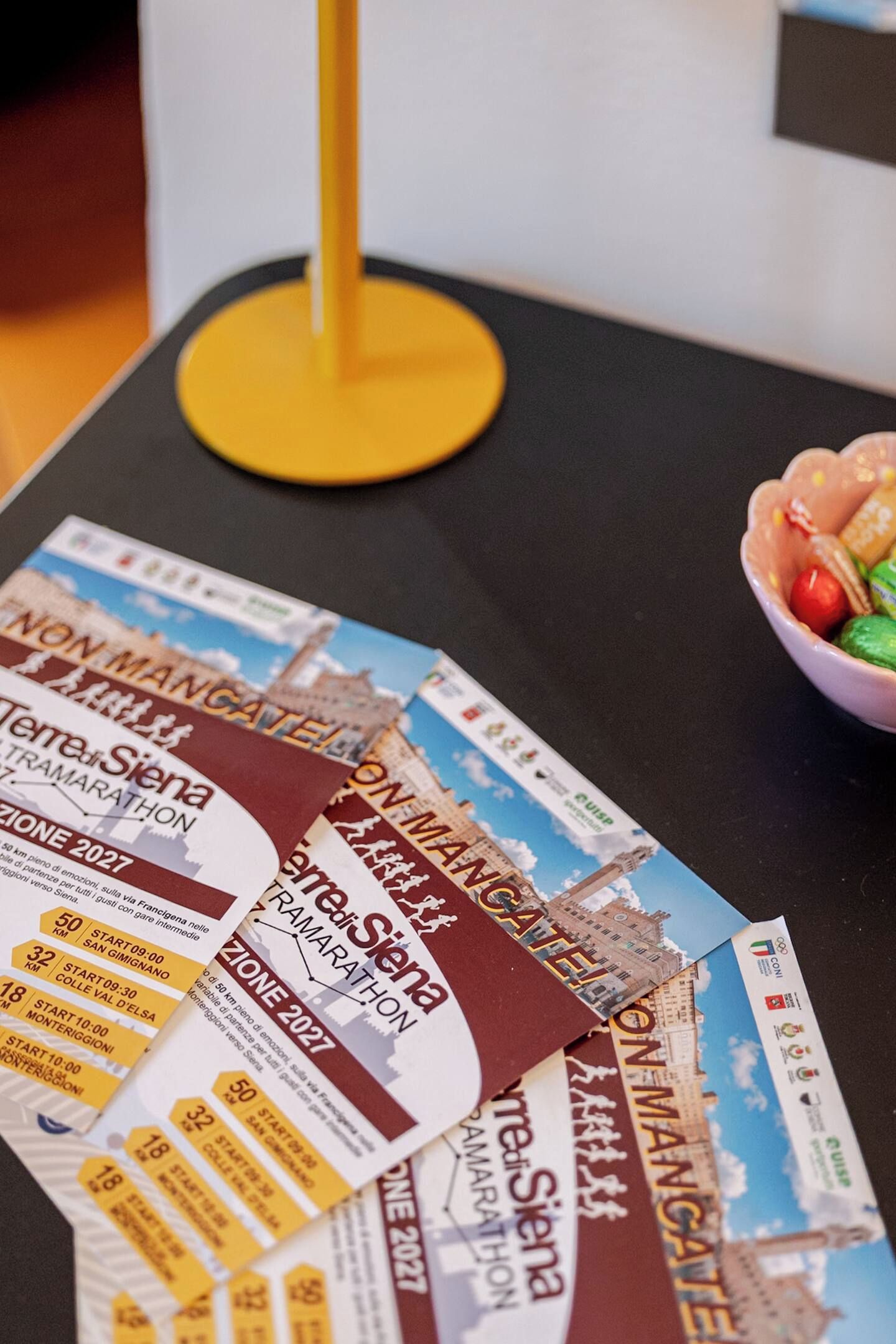 Una mesa con boletos de evento esparcidos y un frutero.