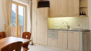 Eine Küche mit Holzausstattung, einer eingebauten Mikrowelle und einem Fenster mit Blick ins Freie.