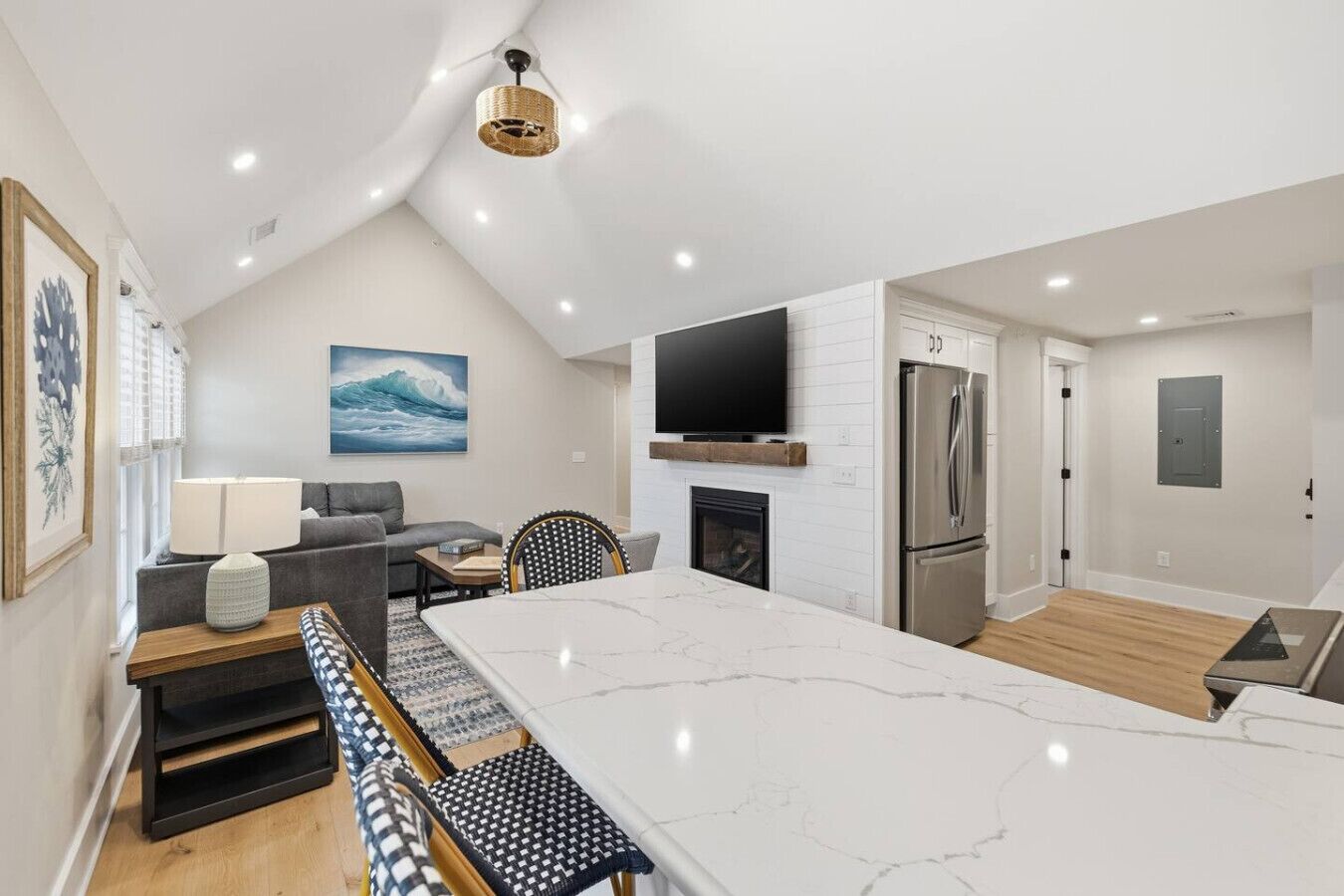 A modern kitchen with a large island, built-in appliances, and a dining area with a view of the living room.