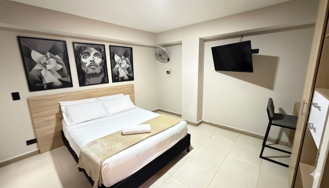 Una habitación de hotel moderna con una cama, un televisor y arte abstracto en la pared.