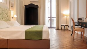 A hotel room with a bed, a desk, a chair, a wardrobe, and a view of the outside. - BERETTI HOME (Catania)