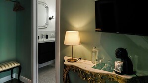 A bathroom with a sink, mirror, vanity with a lamp, and a television mounted on the wall. - BERETTI HOME (Catania)