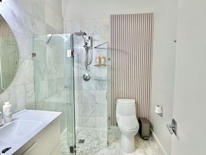 Ein modernes Badezimmer mit einer Duschkabine, einer Toilette und einem Waschbecken.