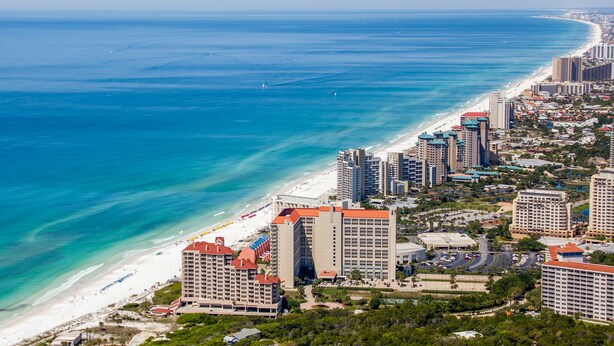 A coastal cityscape with high-rise buildings, a beach, and a marina. - 2BR condo with pool view & beach access (Miramar Beach)