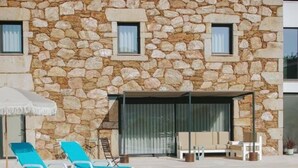 A stone building with a swimming pool, lounge chairs, and a covered seating area. - Sandoco House Golf Adventure (Ponte de Lima)