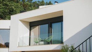 A modern building with a balcony, large windows, and a clear view of the surrounding trees. - Sandoco House Golf Adventure (Ponte de Lima)