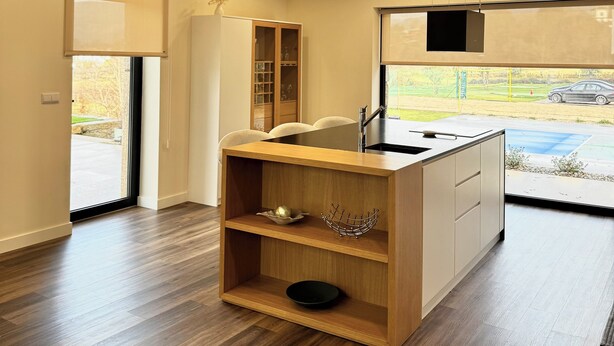 A modern kitchen with a wooden island, recessed ceiling lights, and a view of the outdoors. - Sandoco House Golf Adventure (Ponte de Lima)