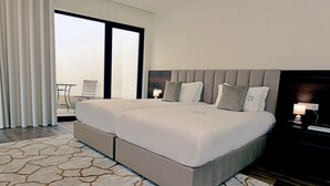 A large bed with a headboard, a bedside table with a lamp, and a view of the outdoors through a sliding door. - Sandoco House Golf Adventure (Ponte de Lima)