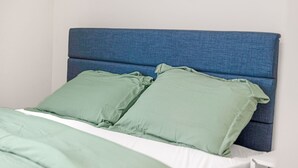 A bed with a blue headboard and green bedding. - Cozy Indy Retreat. Walk to Lucas Oil & Downtown. (Indianapolis)