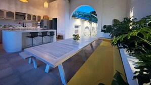 Cocina tipo loft con comedor, asientos de bar y vistas a través de un arco.