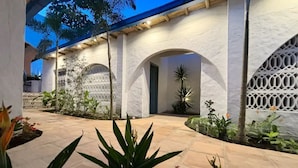 Un patio con paredes blancas, arcos y plantas en macetas.
