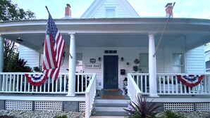 A house with a porch, an American flag, and a sign reading 'Conch House.' - Spacious 2-Bedroom Coastal Retreat with Luxurious Marble Shower – Beaufort, NC (Beaufort)