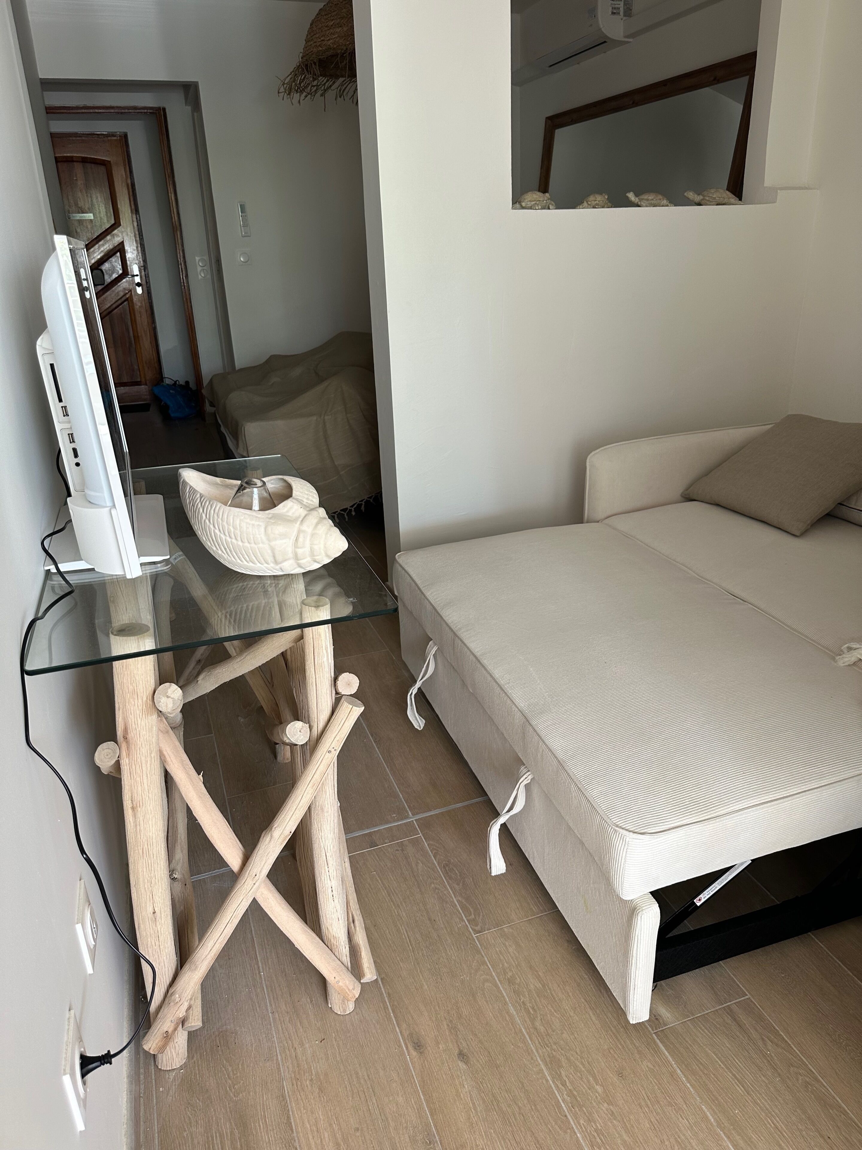 A bedroom with a glass-top desk, a bed, and a wooden chair.