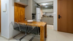 Une cuisine compacte avec un coin repas, une table en bois et des chaises.