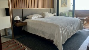 A modern hotel room with a large bed, a nightstand, a lamp, and a view of the outdoors. - Department La Cruz de Huanacaxtle, Nayarit. With two bedrooms with bathroom (Cruz de Huanacaxtle)