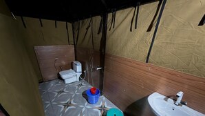 Un bagno piccolo con il water, un lavandino e piastrelle decorative sul pavimento.