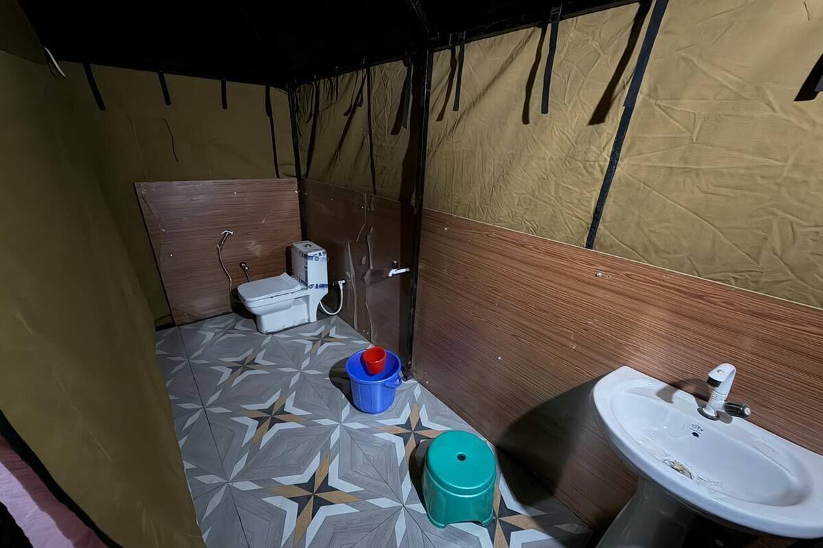 Un baño pequeño con inodoro, lavamanos y baldosas de suelo estampadas.