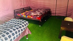 Una stanza con un letto, una sedia e un tavolino.