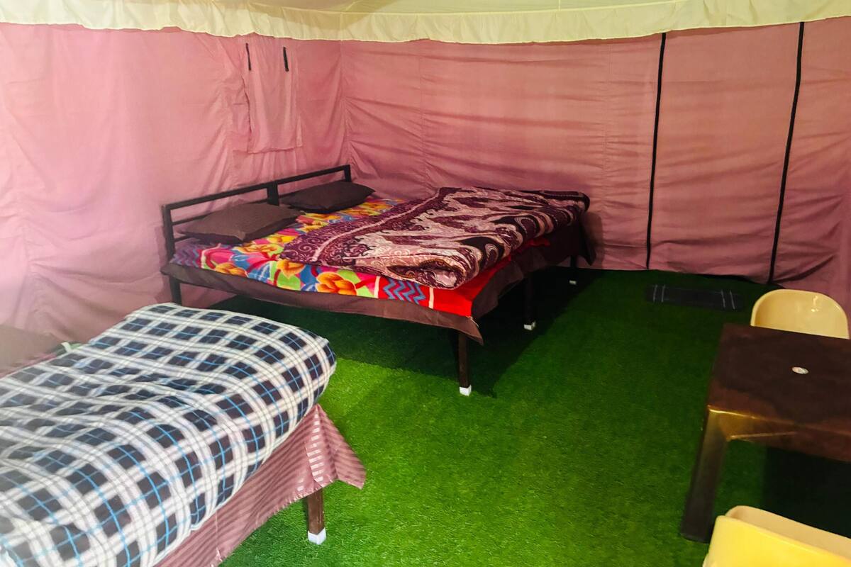 Una habitación con una cama, una silla y una mesita.