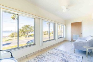 A spacious room with large windows, a white sofa, and a small round table.