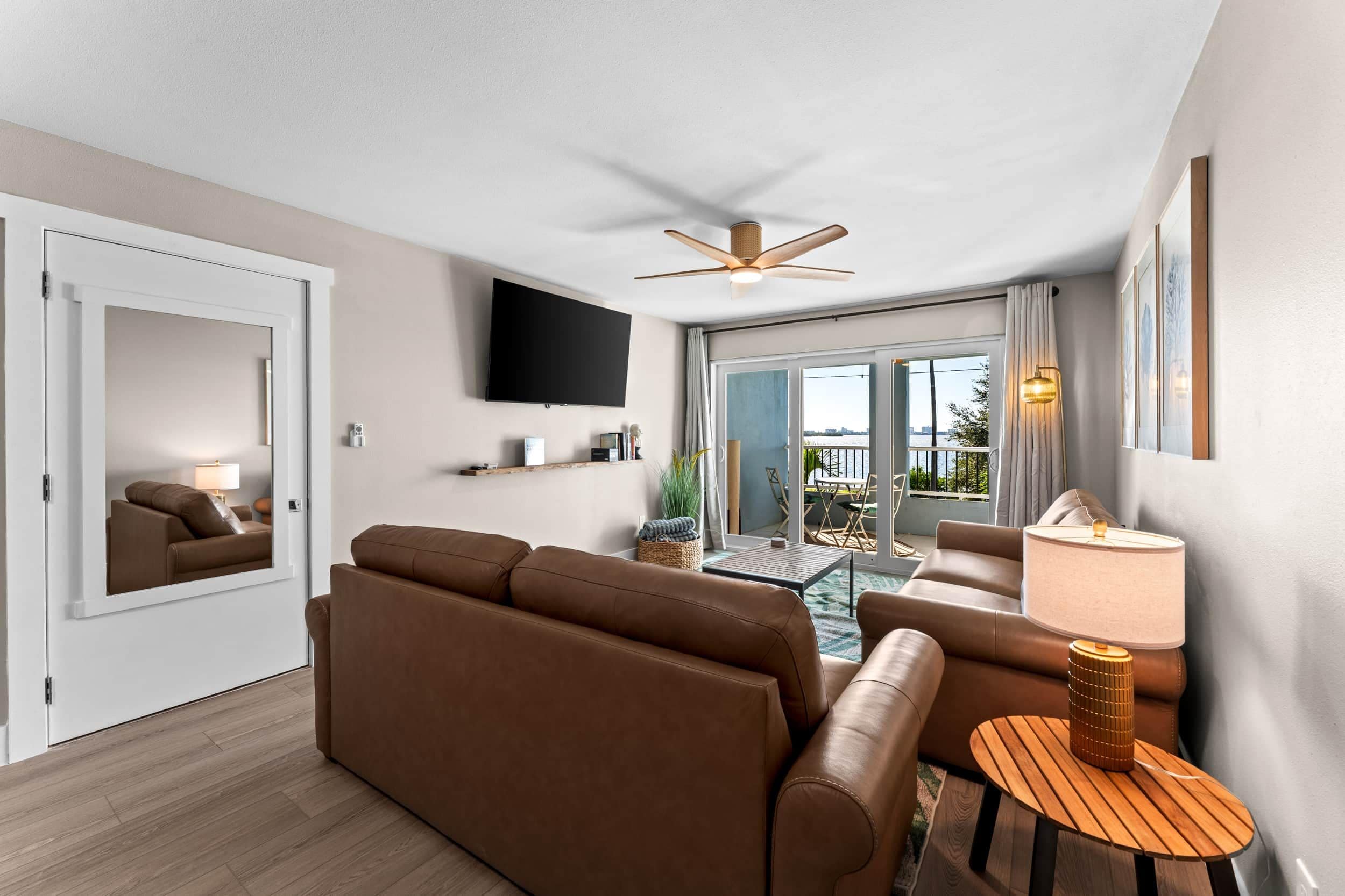 A modern living room with a sofa, a coffee table, and a TV mounted on the wall.