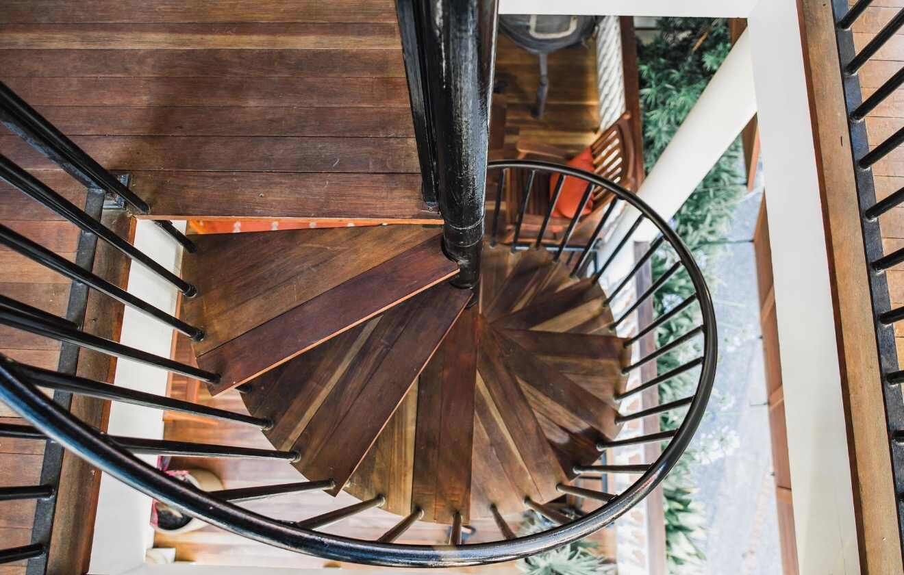 A spiral staircase with wooden steps and metal railings.