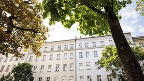 Un edificio a più piani con facciata simmetrica, ampie finestre e un ingresso centrale.