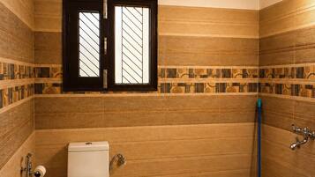 Une salle de bain équipée de toilettes, d’un bidet, d’une serpillière et d’un seau.