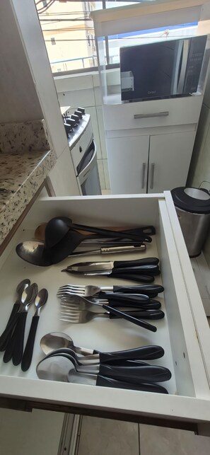 A kitchen with a microwave, stove, and cabinets. - 450m from the beach. Functional apartment, 500MB Wi-Fi, garage, sleeps up to 5 people. (Balneário Camboriú)