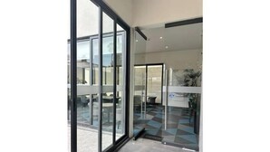 A modern hotel lobby with large glass doors, a checkered floor, and a visible reception desk. - Splendid apartment in the heart of Colonia Americana (Guadalajara)