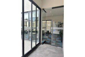 A modern hotel lobby with large glass doors, a checkered floor, and a visible reception desk. - Splendid apartment in the heart of Colonia Americana (Guadalajara)
