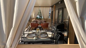 An outdoor dining area with a table set for two, surrounded by wicker chairs, a grill, and a sofa. - Vacation in Sukošan, Comfortable Mobile Home for 5 Adults or 4 Adults and 2 Children (Sukošan)