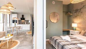Un intérieur moderne comprenant un coin repas, une cuisine et une chambre avec un lit et une table de chevet.