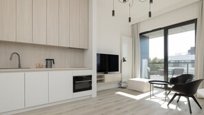 A modern kitchen with built-in appliances, a dining area with a table and chairs, and a large window offering a view of the outdoors. - Widok na Morze | Przy Plaży | Taras | Shellter (Rogowo)