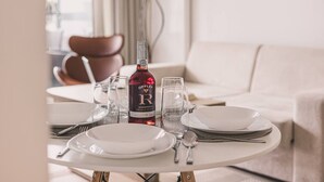 Ein Esstisch gedeckt mit Tellern, Gläsern, Besteck und einer Flasche Offley Roseporto Wein.