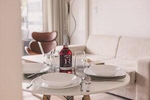 Ein Esstisch gedeckt mit Tellern, Gläsern, Besteck und einer Flasche Offley Roseporto Wein.