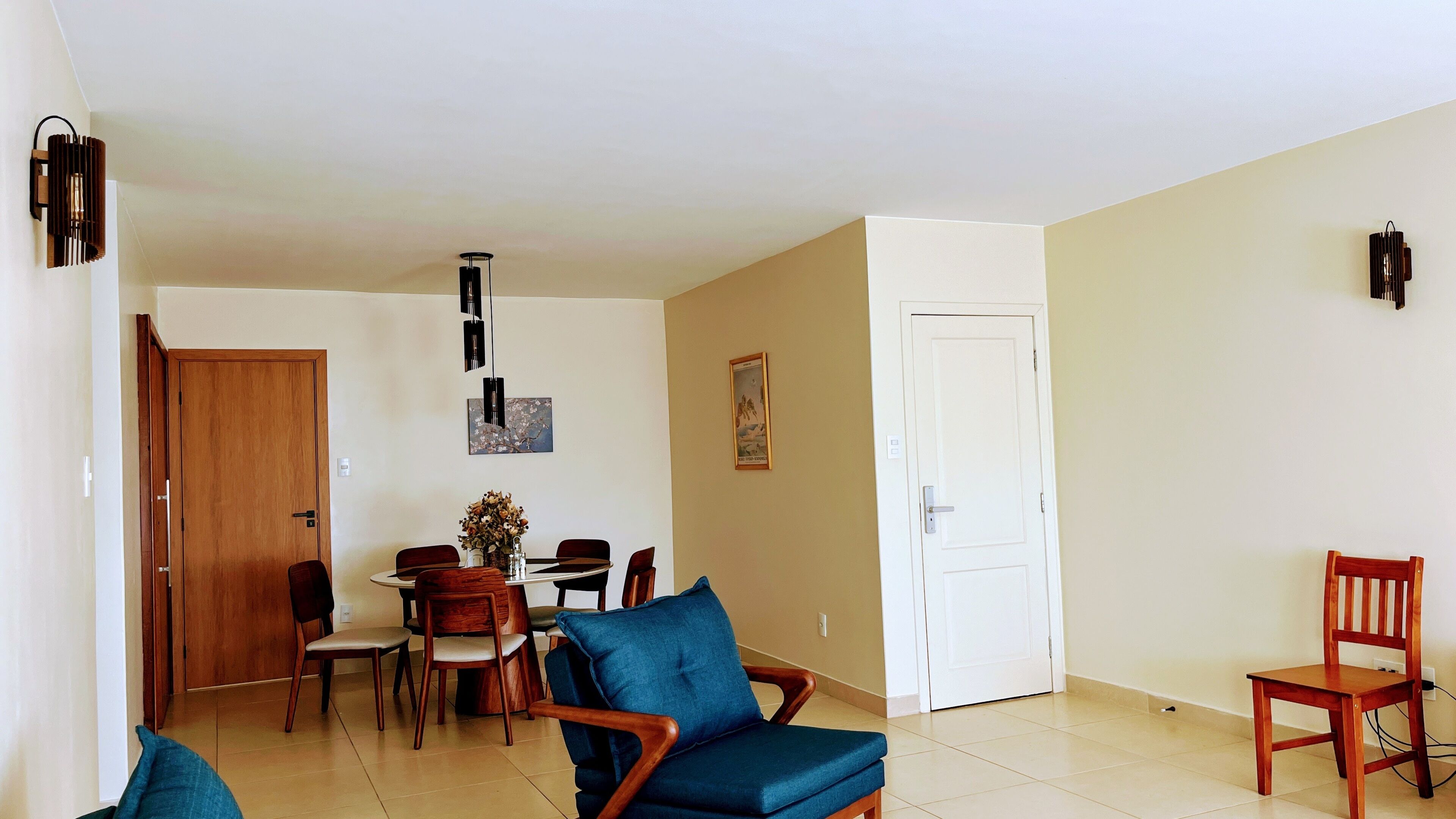 Una sala de estar con sofá, sillas, mesa de comedor y una puerta.