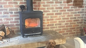 A brick wall with a wood-burning stove. - Farnah House Barn (Belper)
