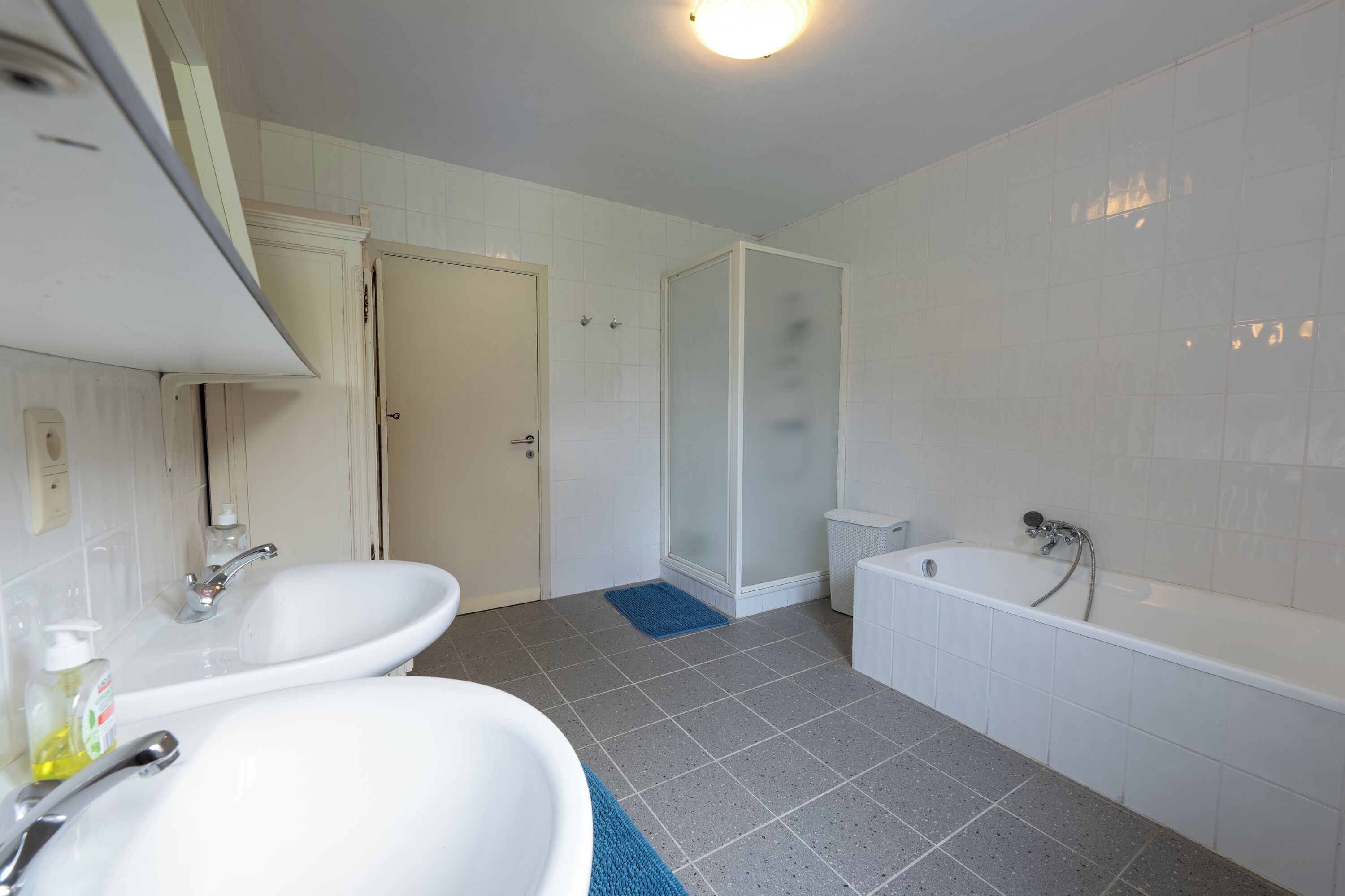 A bathroom with two sinks, a shower, and a bathtub.
