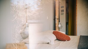 Ein Schlafzimmer mit Bett, Kissen, Nachttisch und Lampe.