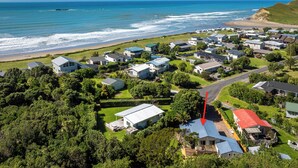 Un quartier résidentiel situé sur la côte, avec des maisons, une plage et une vue dégagée sur l’océan.