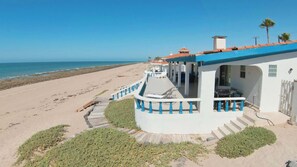A beachfront property with a covered patio, a staircase leading to the entrance, and a view of the ocean. - Beautiful Beachfront Home Casa de Veranos (Puerto Peñasco)