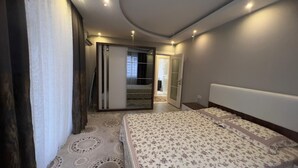 A bedroom with a bed, a wardrobe, and a door leading to a bathroom. - LOVELY  RESİDENCE 2+1 CLOSE TO SEA WİTH POOL (mahmutlar)