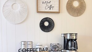 A coffee bar with a coffee machine, mugs, and a sign that reads 'but first Coffee.' - The Cozy Chalet (Asheville)