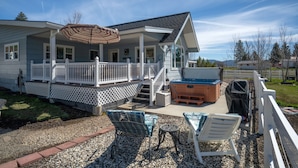 A house with a covered porch, outdoor seating, and a hot tub. - Mountain View Escape | Hot Tub, Fire Pit & Games (Sattley)