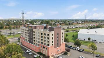 A multi-story hotel with a parking lot in front.