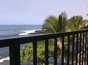 A coastal view with a wooden railing, palm trees, and ocean waves. - Amazing condo in beautiful Kailua-Kona!
Ocean-Front, right on the water's edge. (Kailua-Kona)